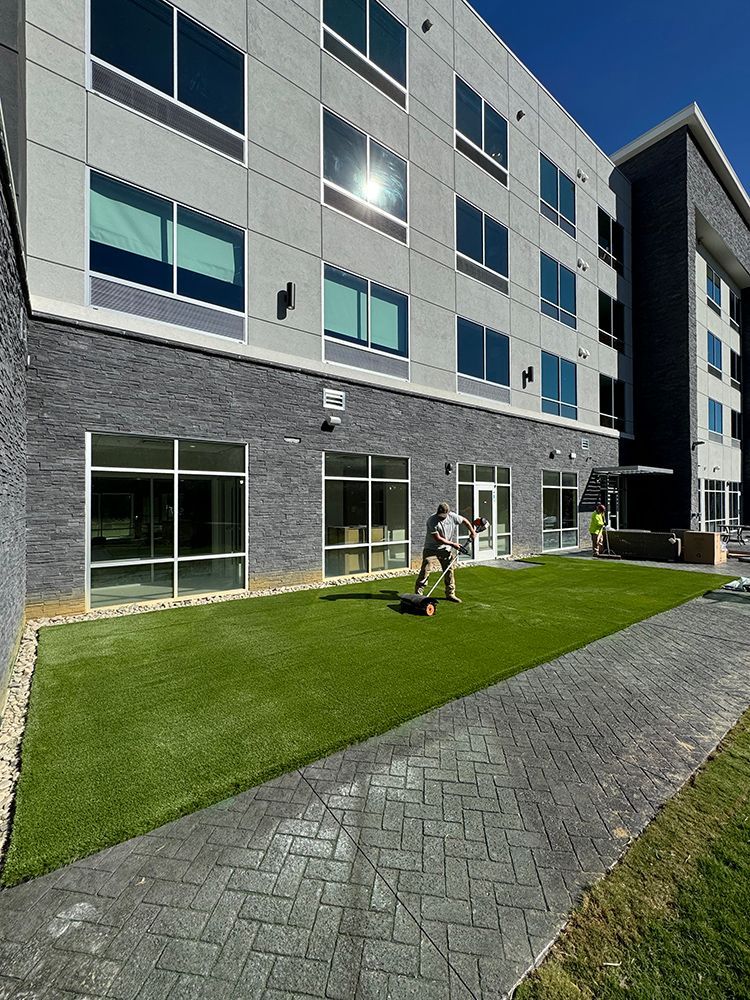 A group of people are playing soccer in front of a large building.
