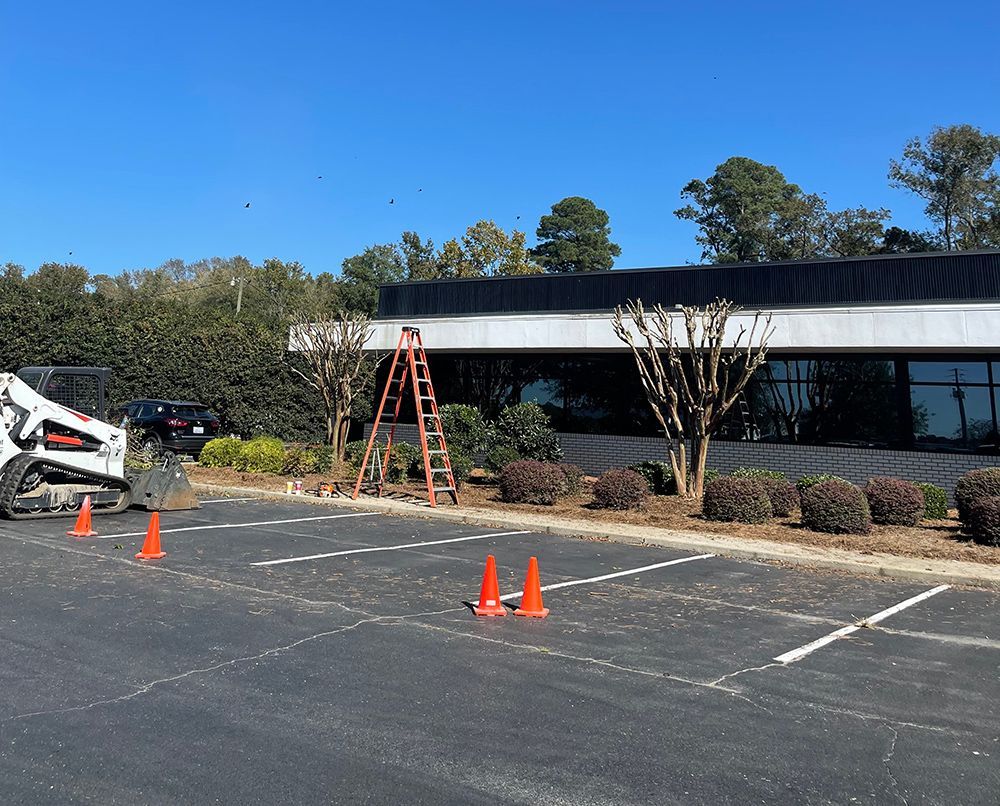A ladder is sitting in a parking lot in front of a building