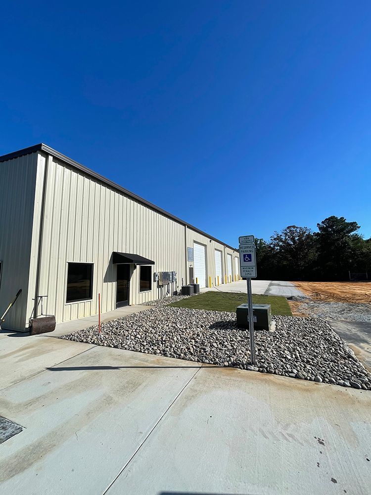 A large white building with a handicapped parking sign in front of it.