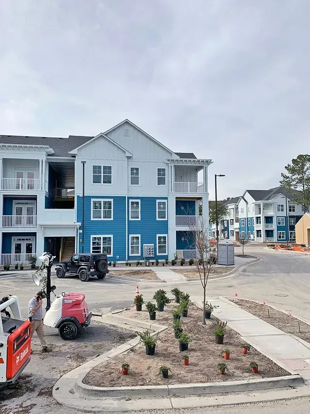 A large blue and white apartment building is under construction.