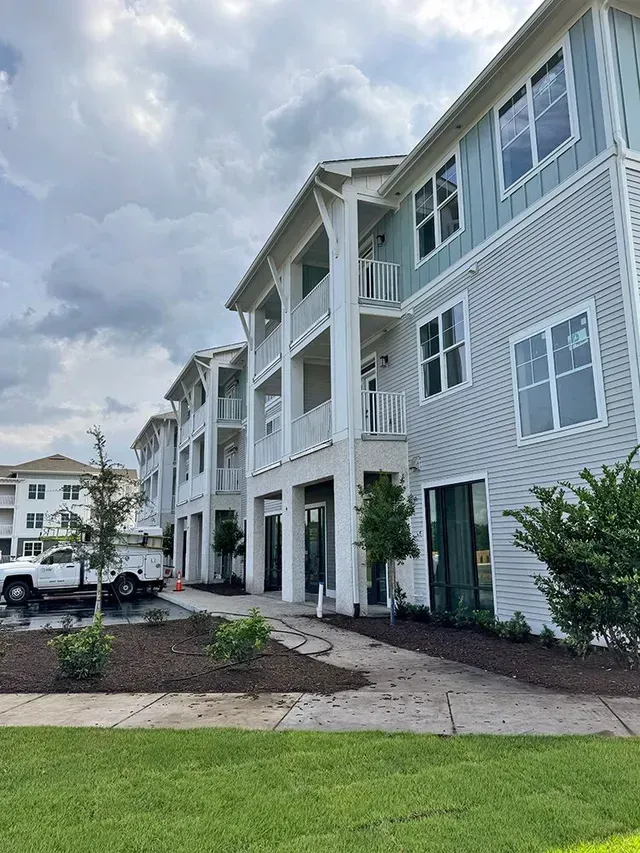 A large white and blue apartment building with a lot of windows.