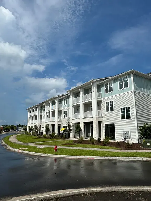 A large apartment building with a fire hydrant in front of it.
