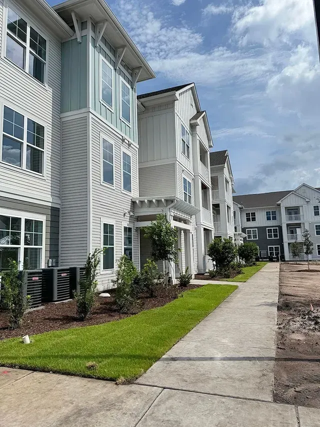 A large apartment building with a walkway leading to it.