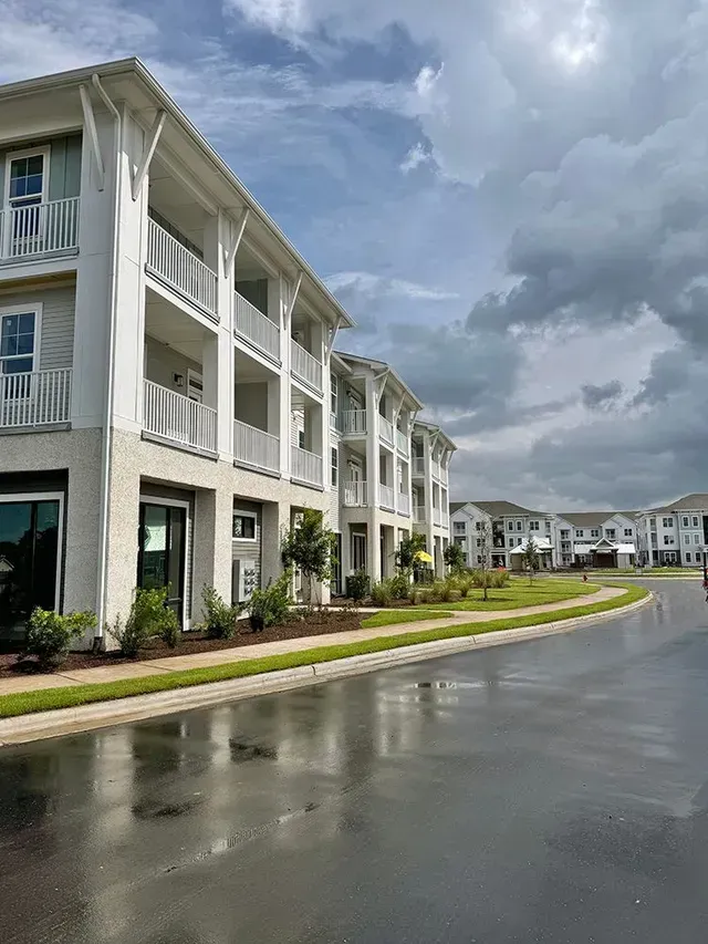 A row of apartment buildings with balconies on a rainy day.