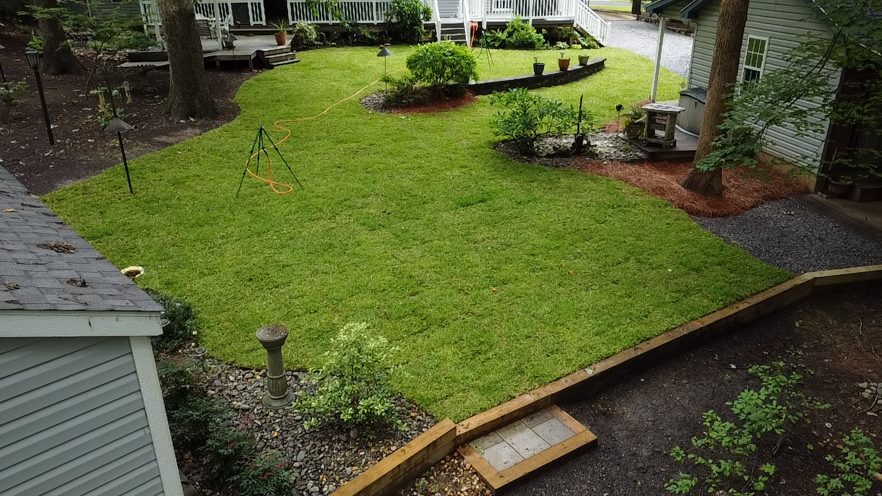 An aerial view of a lush green lawn in front of a house.