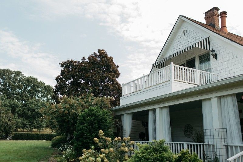 A large white house with a porch and a balcony