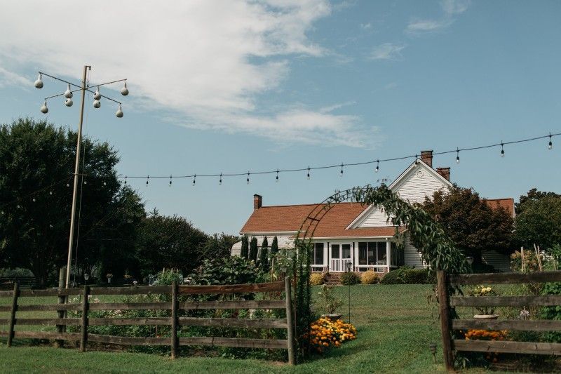 There is a house in the background with a wooden fence in the foreground.