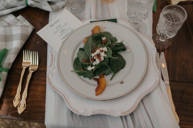 A white plate topped with a salad on a wooden table.