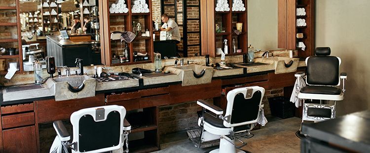 a barber shop with a lot of chairs and mirrors .