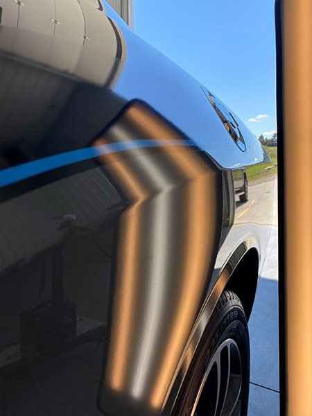 A close up of a car with a dent in the fender