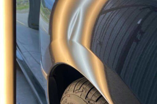 A close up of a car 's fender and tire.