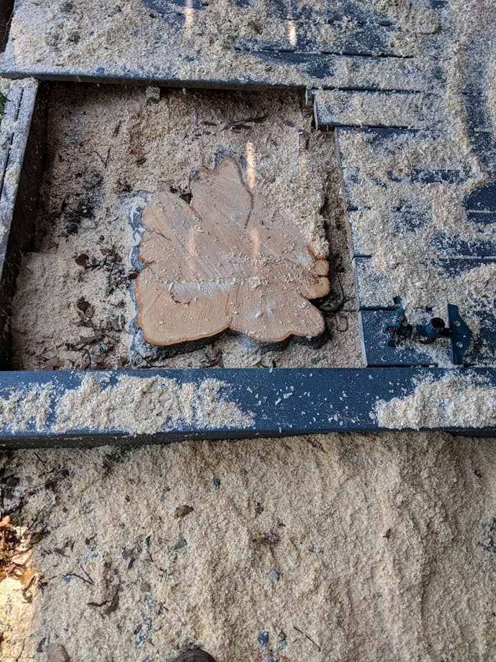 Broken clay tile in a muddy trench with dark framing bars and sand around it