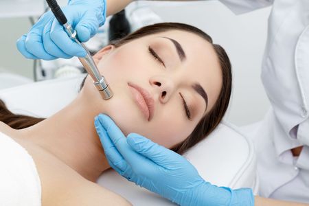 A woman is getting a facial treatment at a beauty salon.