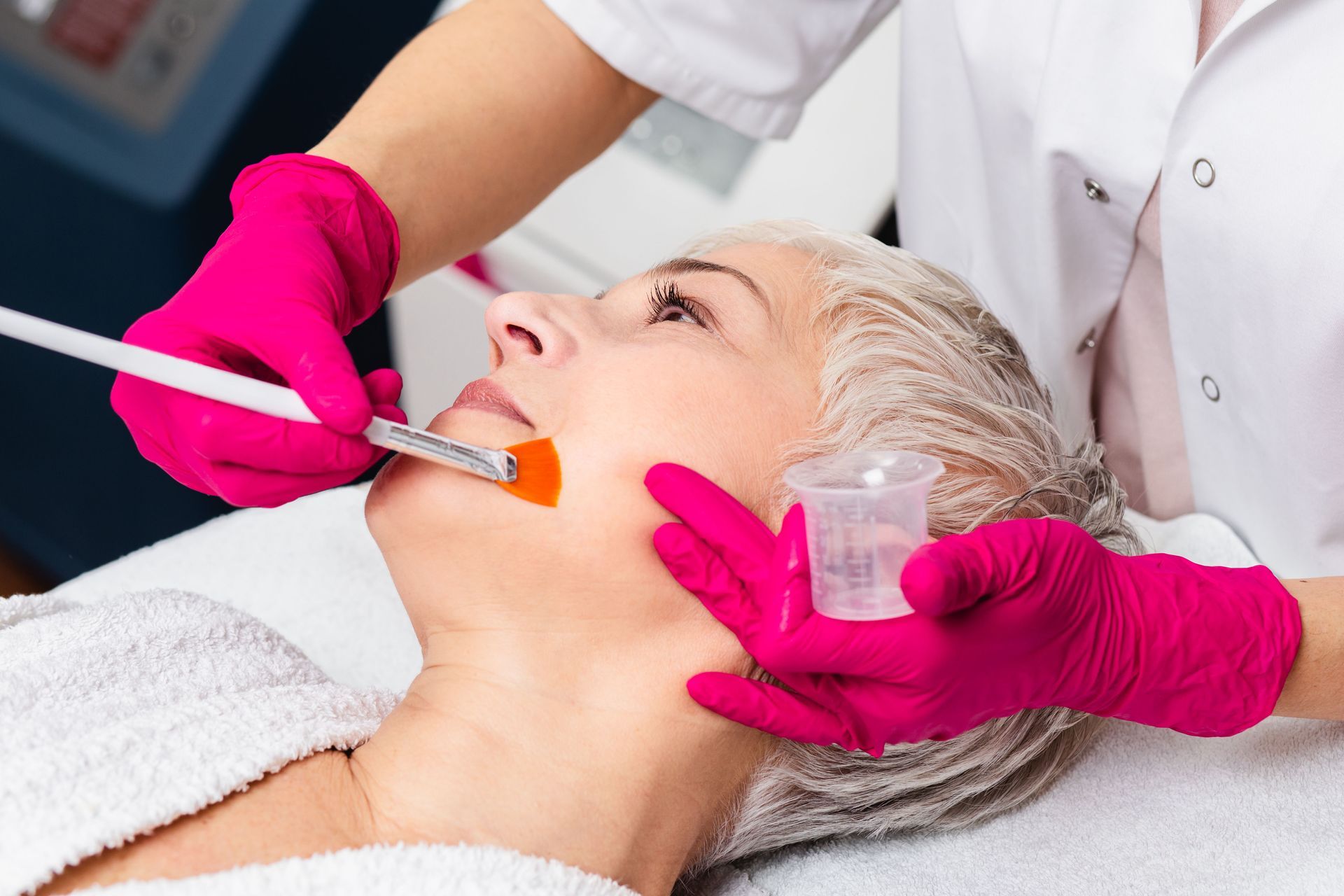 A woman is getting a facial treatment at a beauty salon.