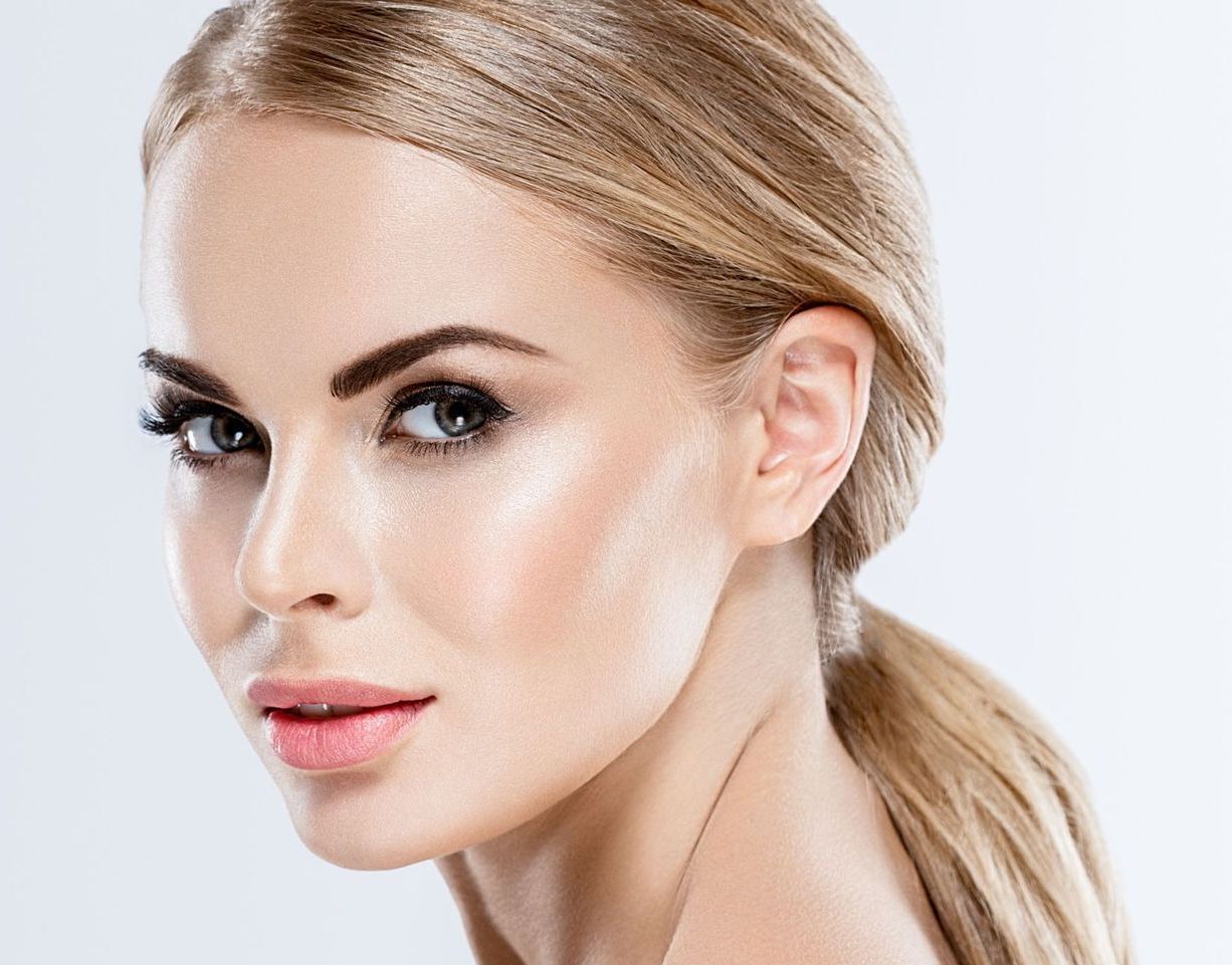A woman is getting a botox injection in her lips.