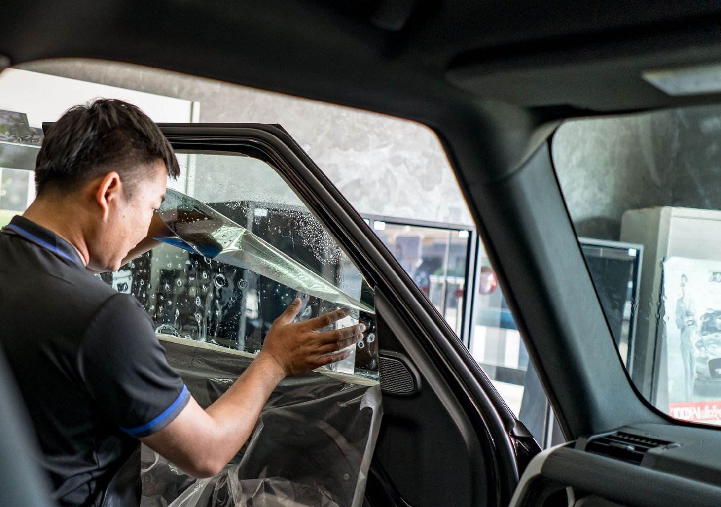 Modern building with brick facade and wood-paneled upper story, blue windows, against a light blue sky.