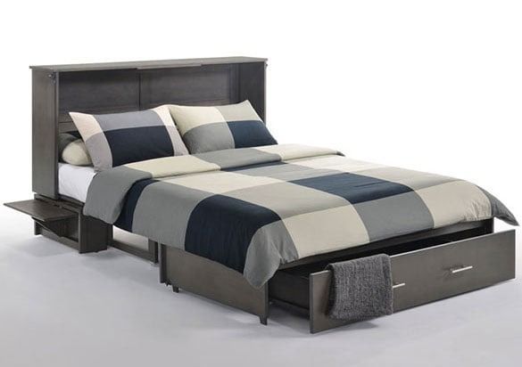 A bed with a blanket and pillows on it and a drawer underneath it.