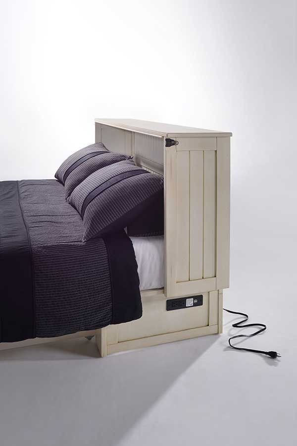 A bed with a wooden headboard and a cord coming out of it.
