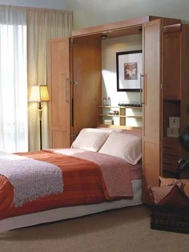 A bedroom with a bed and a wardrobe behind it