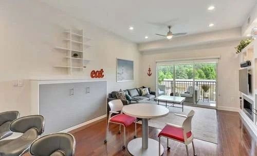 A living room with a table and chairs and a balcony.