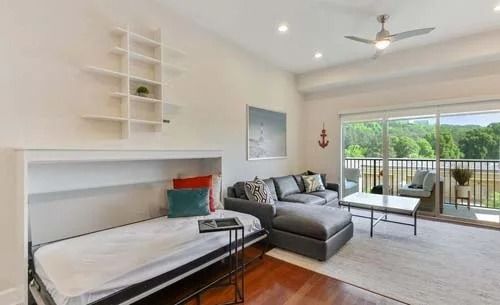 A living room with a couch and a bed.