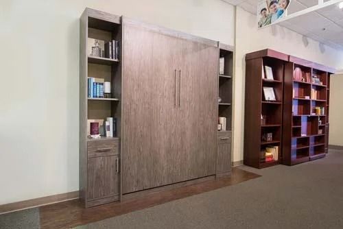 A bed that is turned into a bookshelf in a room.