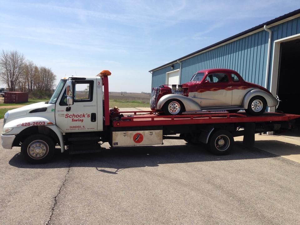 A tow truck with a car on the back of it.