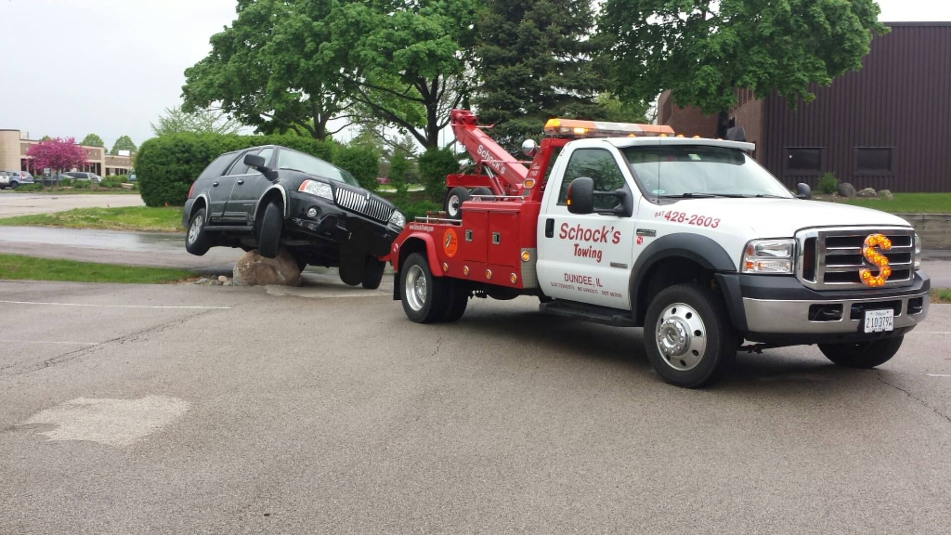 A tow truck towing a black car