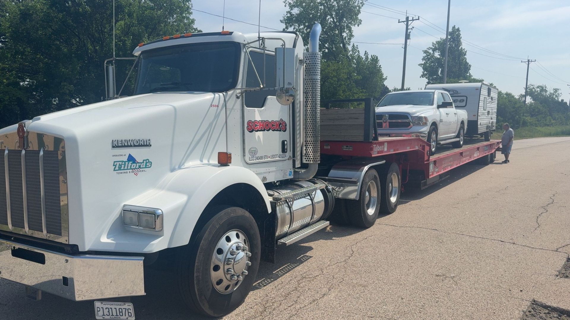 A semi truck is carrying two cars on a flatbed trailer.