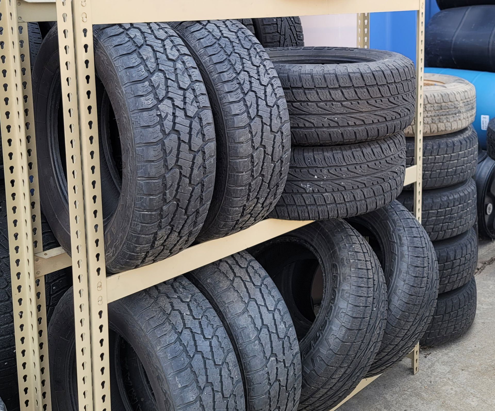 Tires stacked on metal shelves. Black rubber tires arranged in rows, ready for sale or storage.
