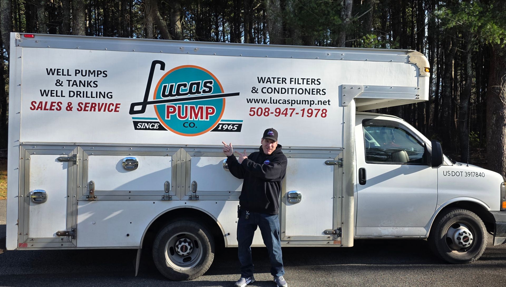Man pointing next to a truck. Truck has 