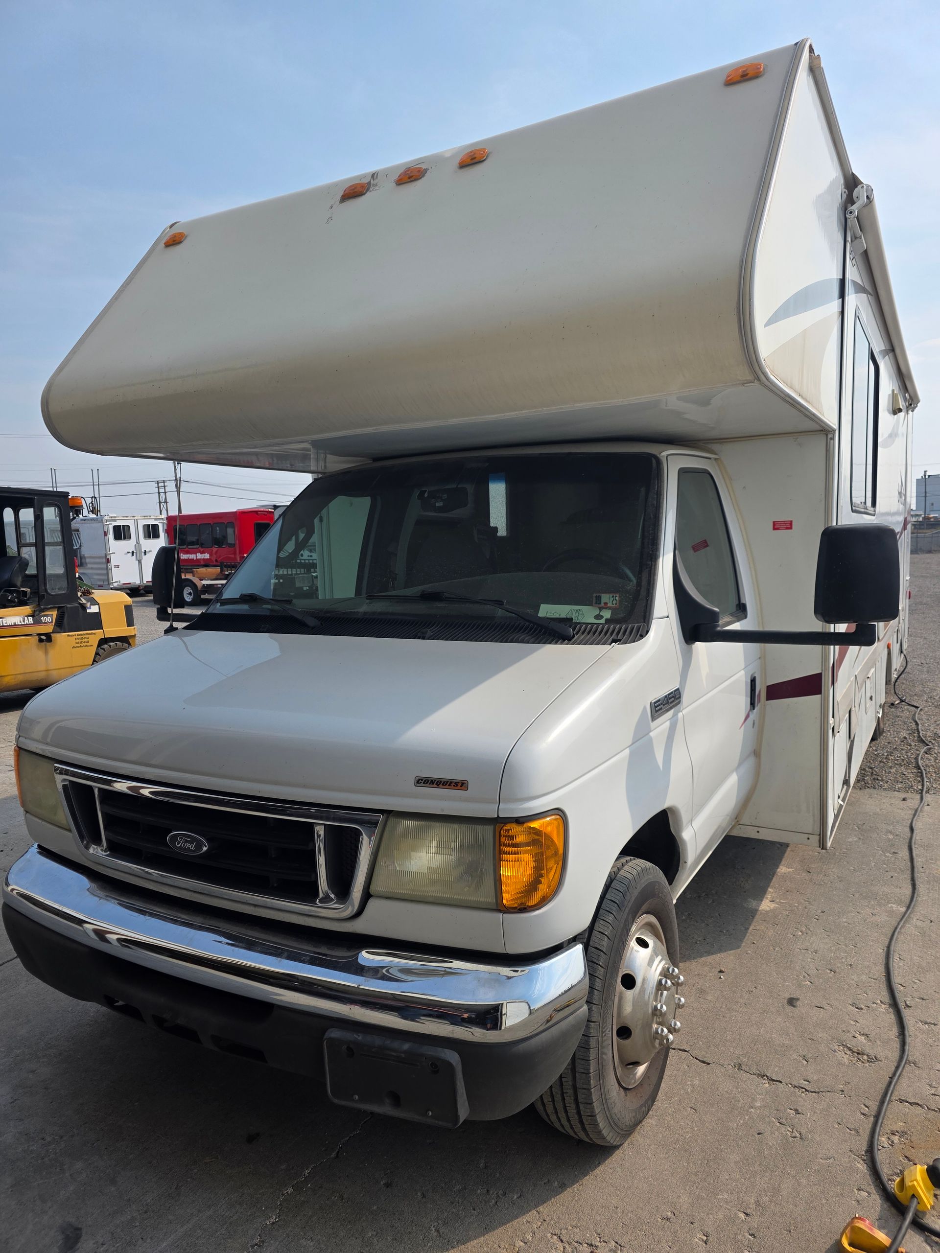 White RV parked outside on a sunny day.