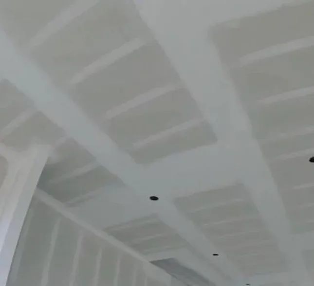 A room with a ceiling that is covered in drywall.