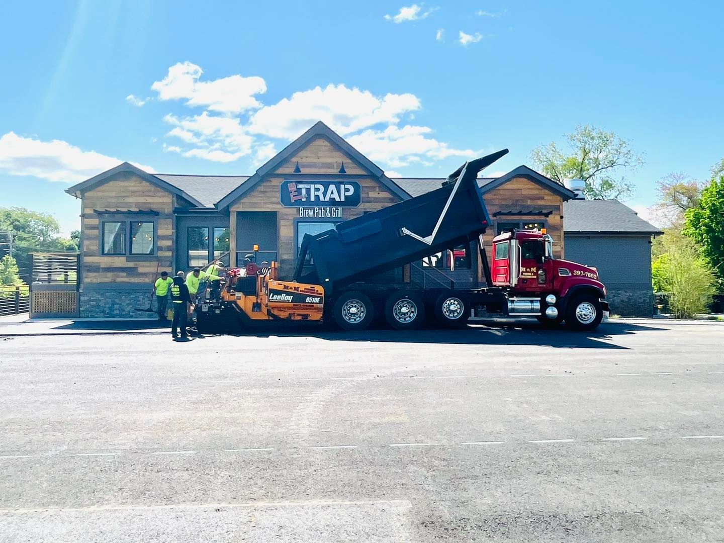 A dump truck is parked in front of a building.