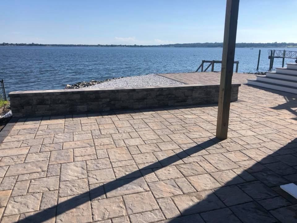 A patio with a view of a lake and a dock.