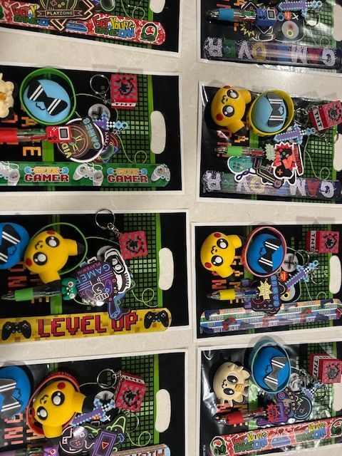 Assorted colorful toy packages with cartoon characters arranged on a shelf, including Pac-Man designs.