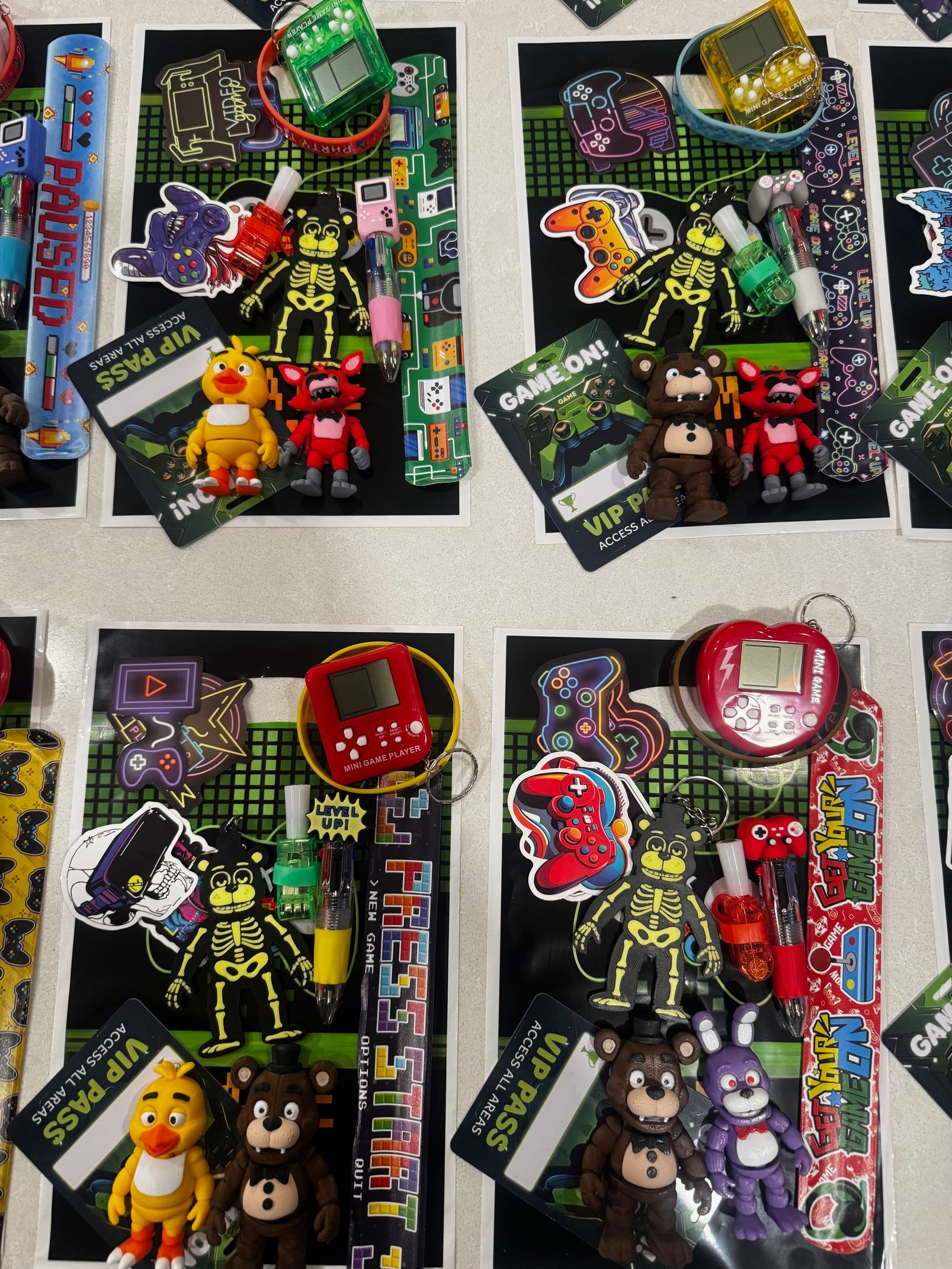 Four small gift bags with colorful toys and treats arranged on a tabletop