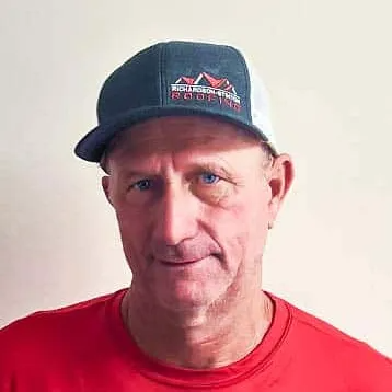 Man wearing a hat and red shirt; looking forward.