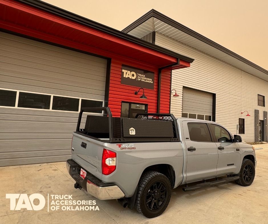 Gray Toyota Tundra with black accessories parked outside a red building; TAO Truck Accessories of Oklahoma.