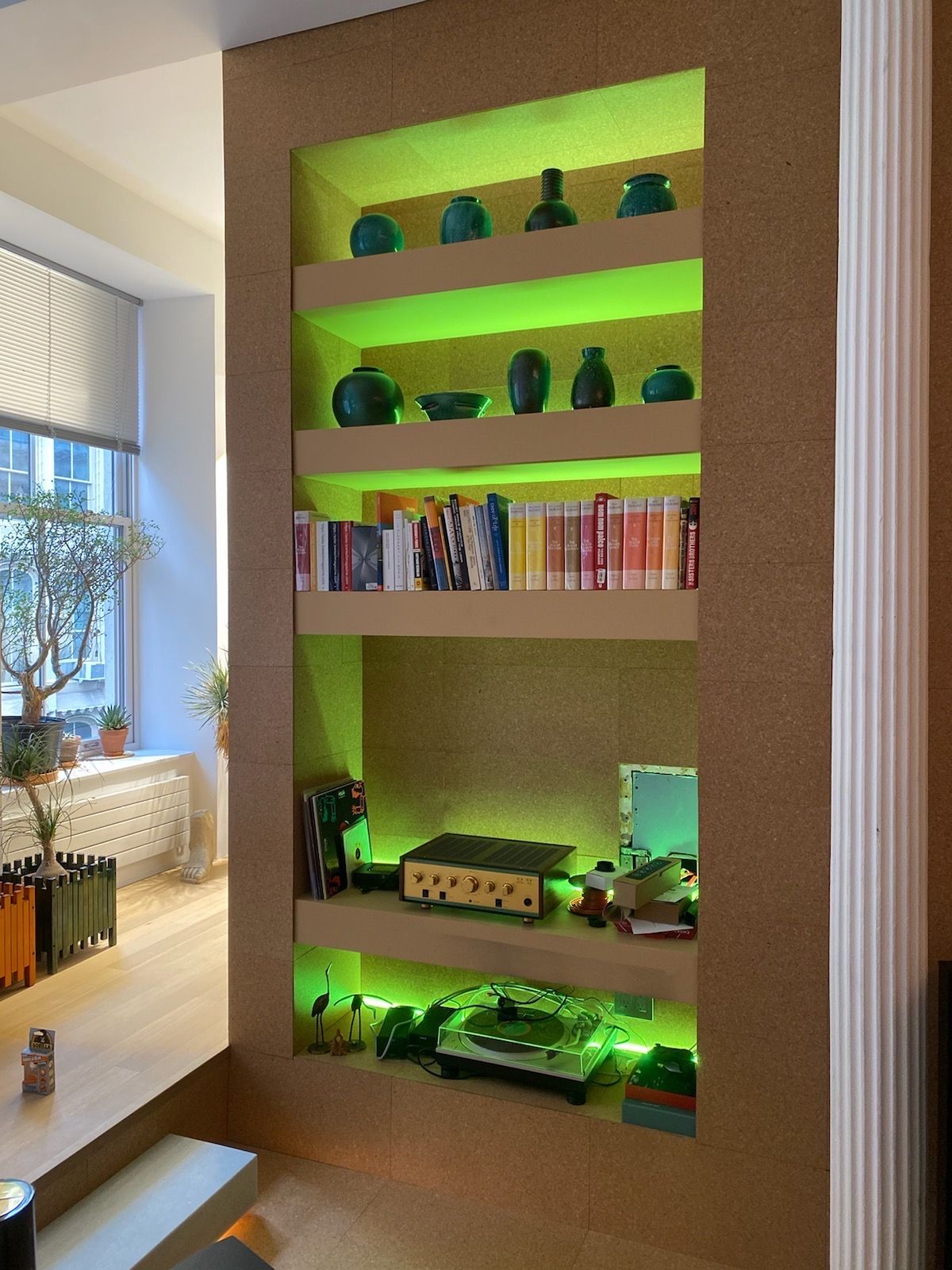 A bookshelf with a green light behind it