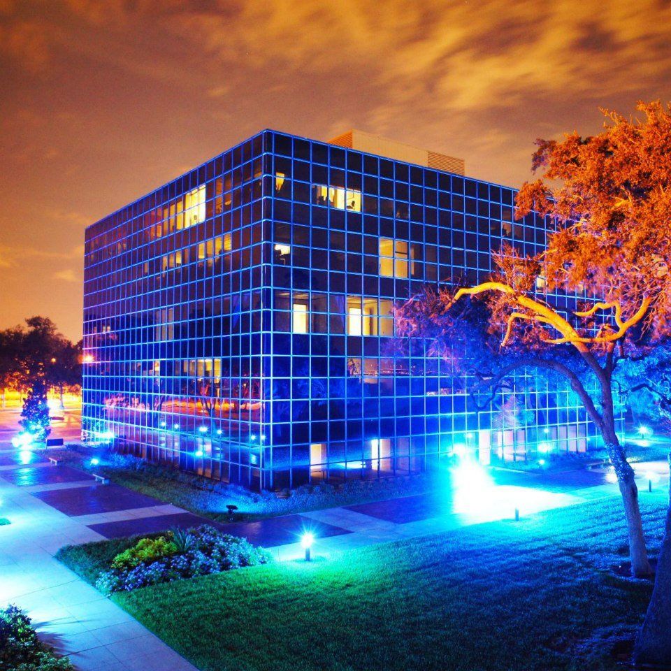 A large building is lit up with blue lights at night