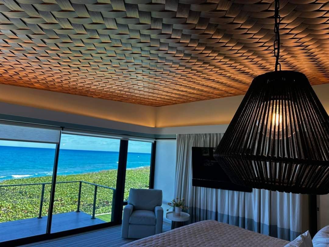 A bedroom with a wicker ceiling and a view of the ocean.