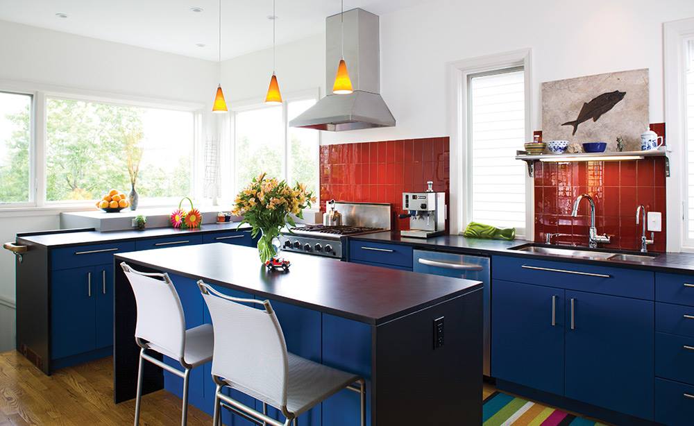 A kitchen with blue cabinets and white chairs
