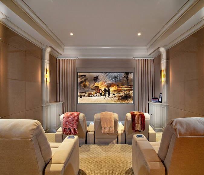 A home theater with three chairs and a large screen