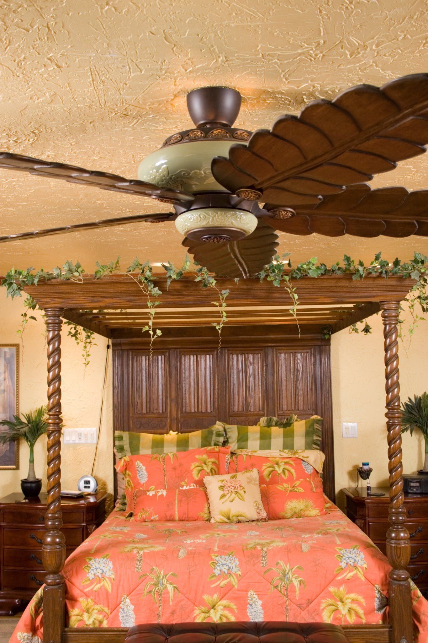 A bedroom with a canopy bed and a ceiling fan