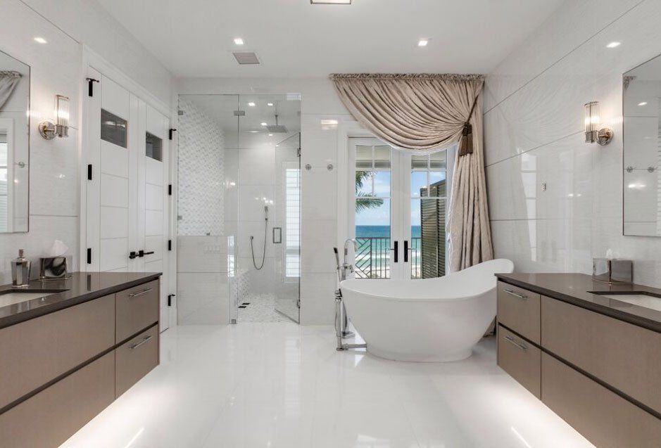 A bathroom with two sinks , a tub and a shower.