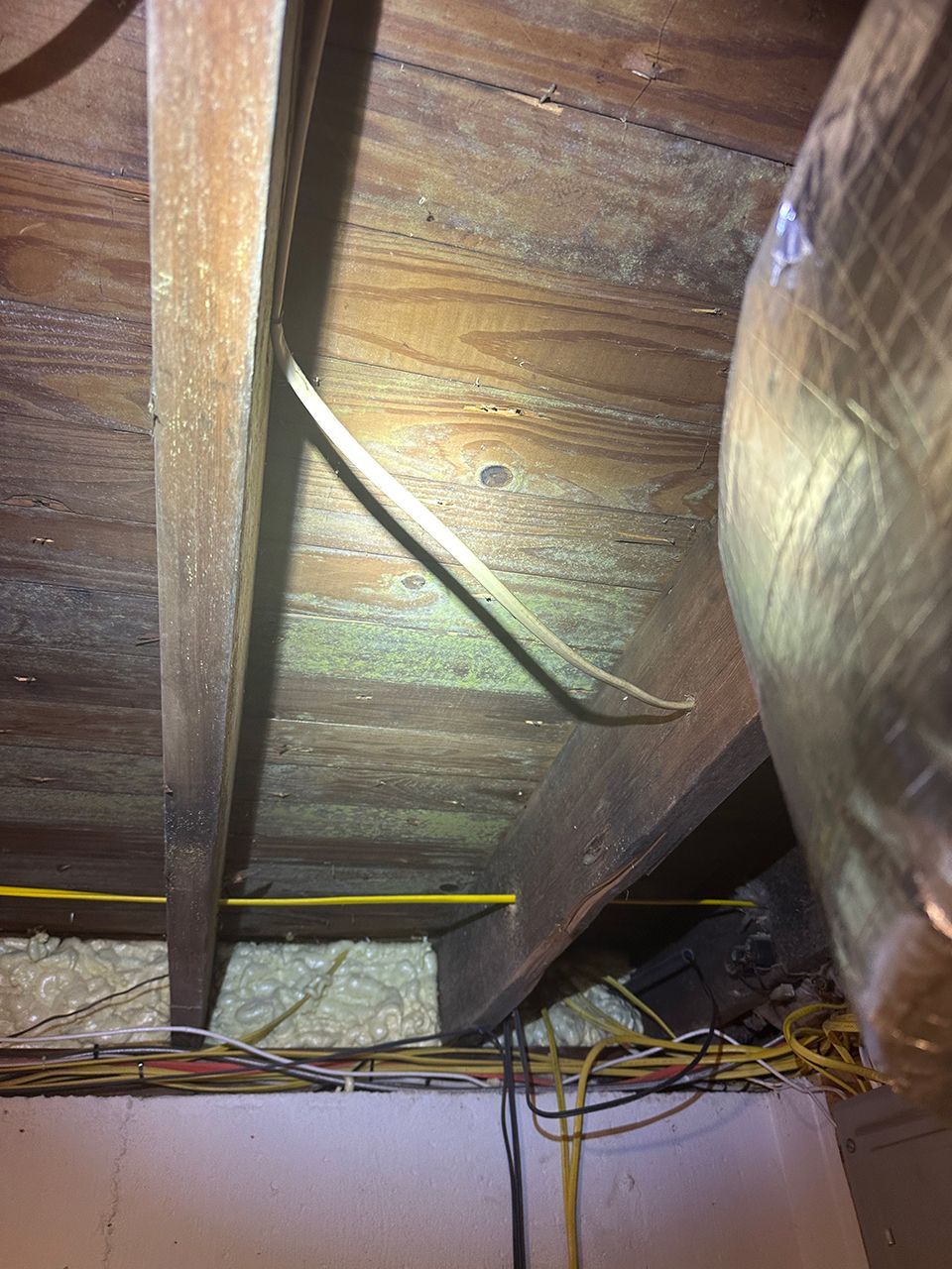 A wooden ceiling with a lot of wires and molds