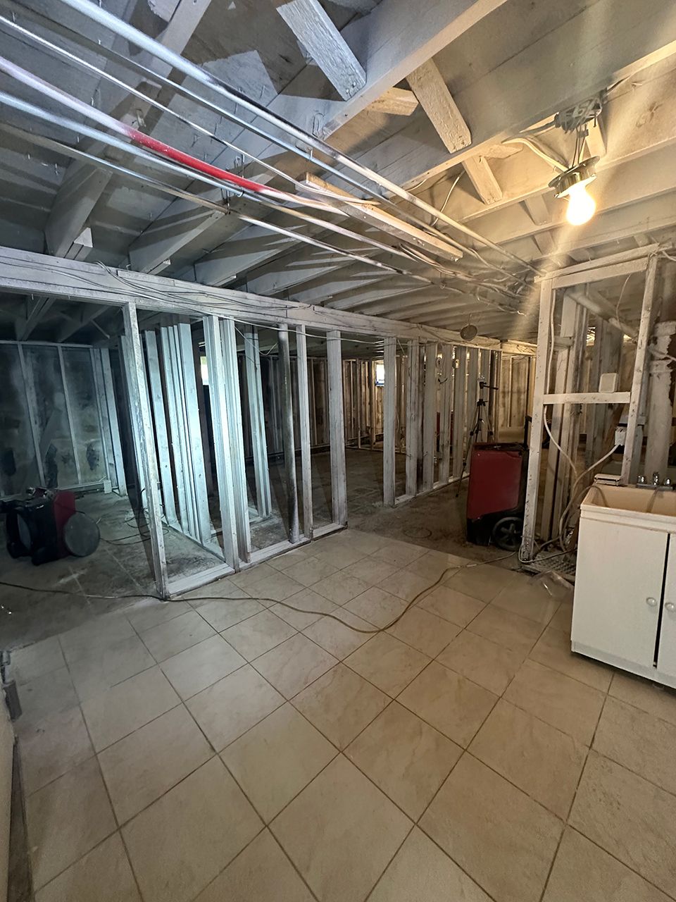 A basement under construction with a washer and dryer in it