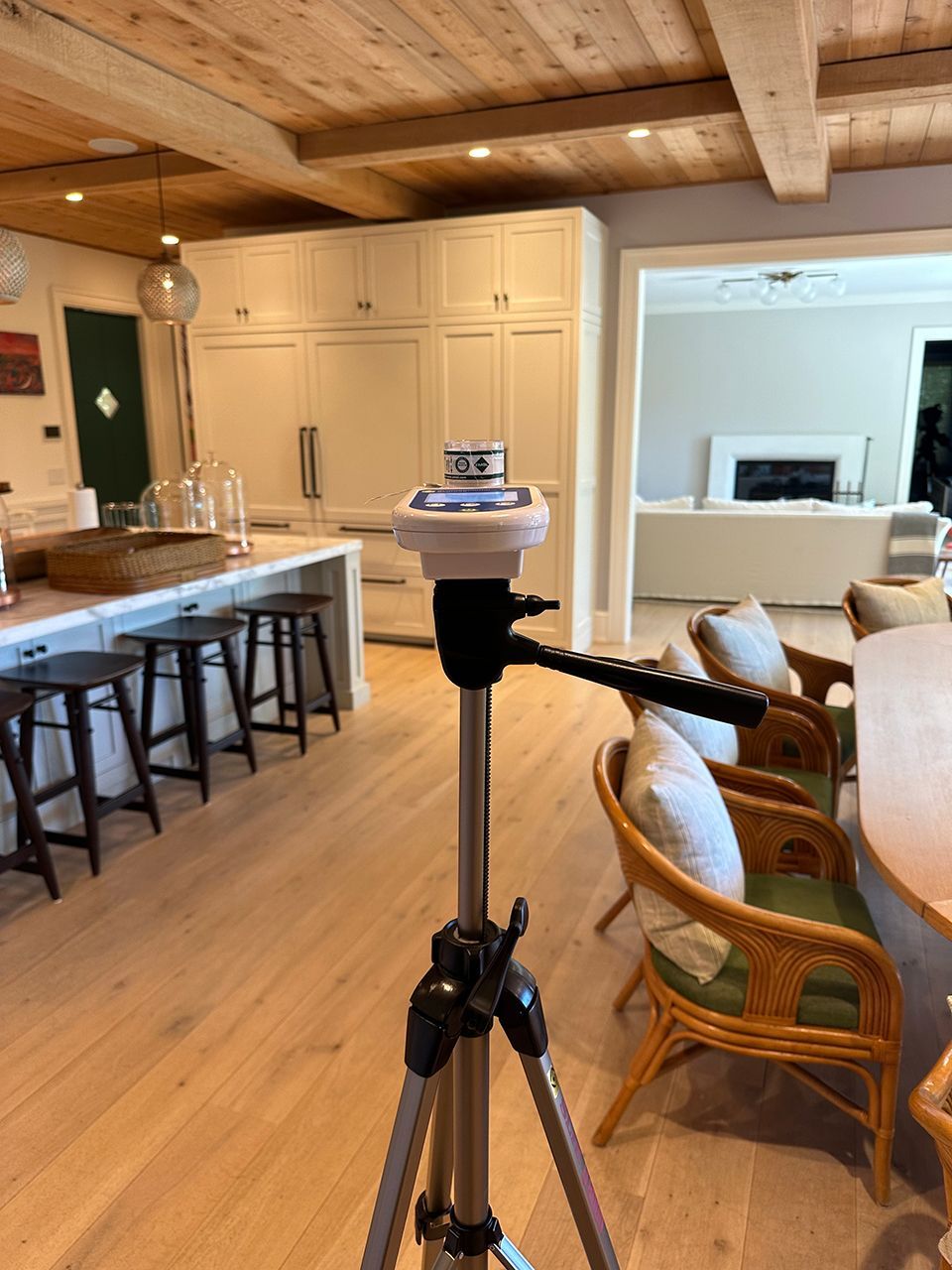 A moisture measuring device is sitting on a tripod in a kitchen