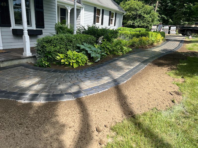 A walkway is being built in front of a white house.